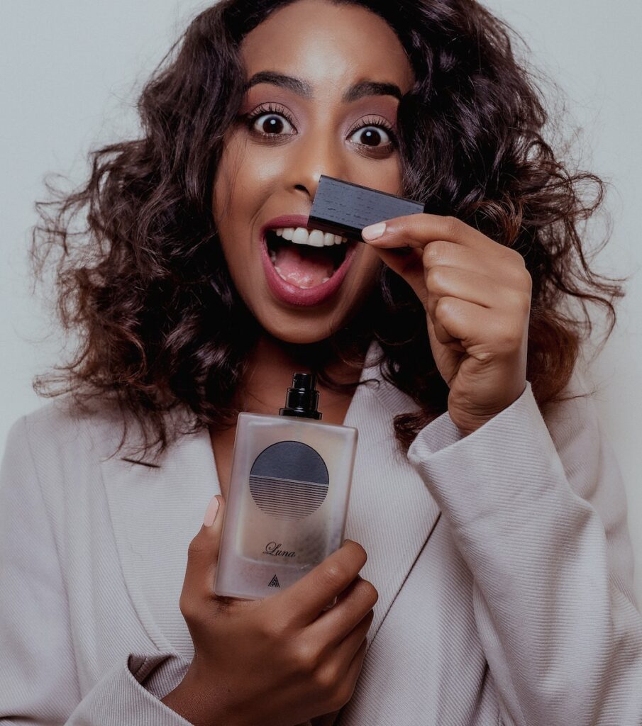 Excited Woman Holding a Bottle of Perfume