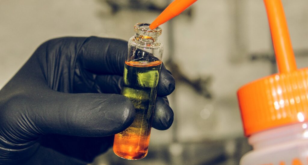 clear glass bottle of perfume with orange handle