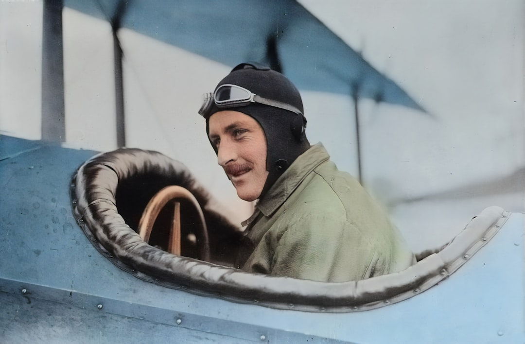 Originally from the Library of Congress, this AI recoloured photograph depicts early aviator Steve MacGordon circa 1915 in the cockpit of a biplane shortly before his death. MacGordon was one of the earliest pioneers in aviation and held many of the inaugural records in flight. by Perfume Brands man inside biplane