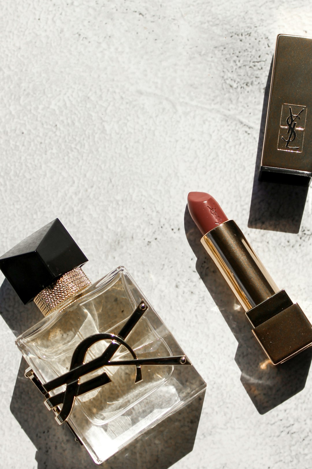 a lipstick and a pair of scissors on a table