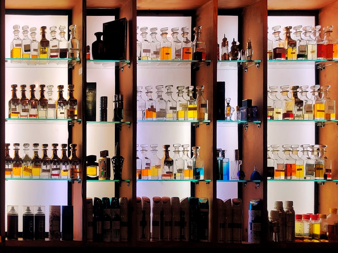 Perfumes in an attracting manner.... by Perfume Brands a shelf filled with lots of bottles of liquor