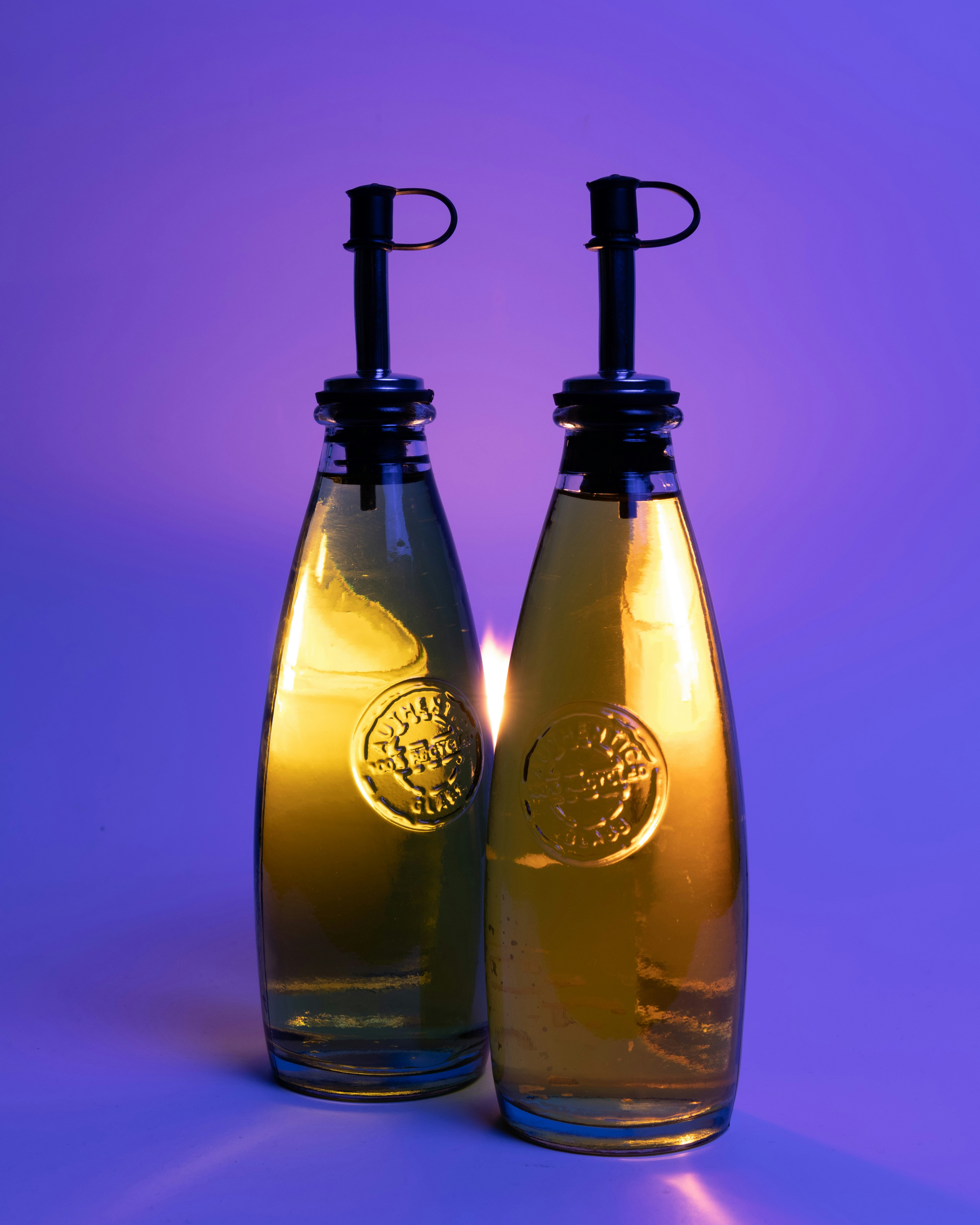 2 clear glass bottles with yellow liquid